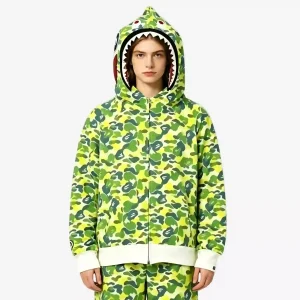 BAPE shark hoodie in green-yellow ABC camouflage pattern, featuring the iconic shark mouth hood design with full-zip closure