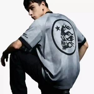 Grey streetwear T-shirt with black trim and a large circular dragon-star graphic on the back, worn by a male model in a studio setting