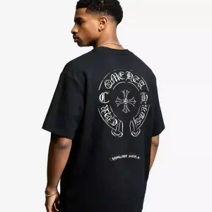 Black oversized streetwear T-shirt featuring a white Chrome Hearts-inspired horseshoe cross graphic on the back, worn by a Black male model in a studio setting