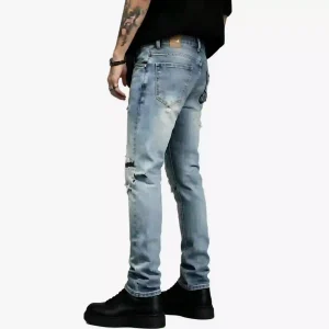 Light blue distressed skinny jeans with faded wash and rips, worn with black platform shoes by a tattooed model