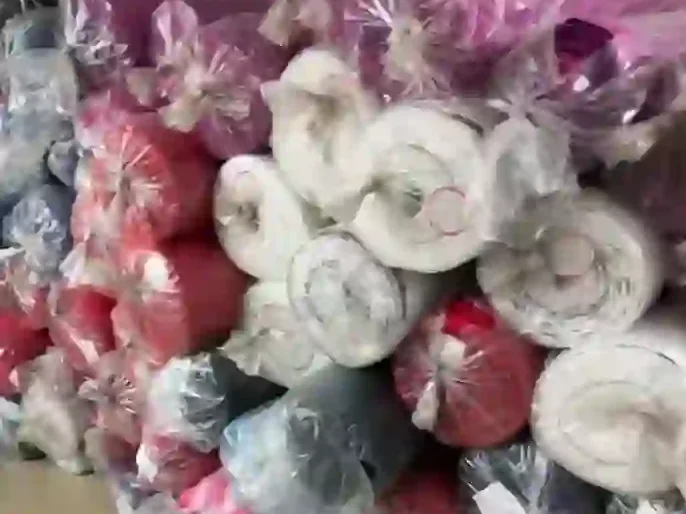 Rolled and packaged bulk clothing orders in plastic bags at a factory warehouse